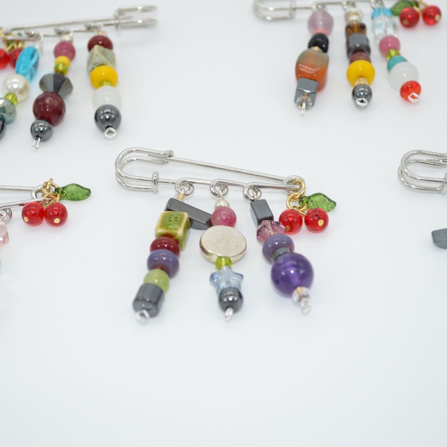 Colorful beaded brooches on a white background