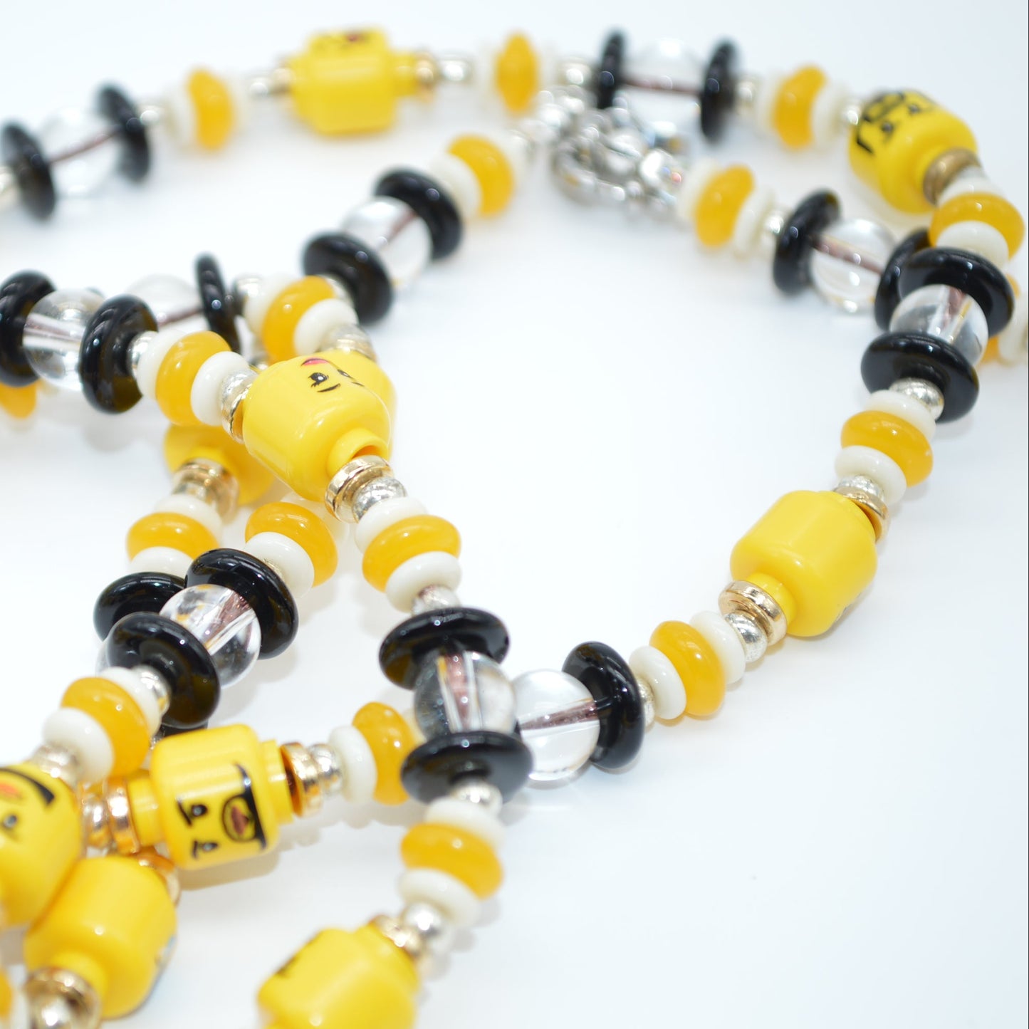 Necklace with yellow, black, and silver beads on a white background