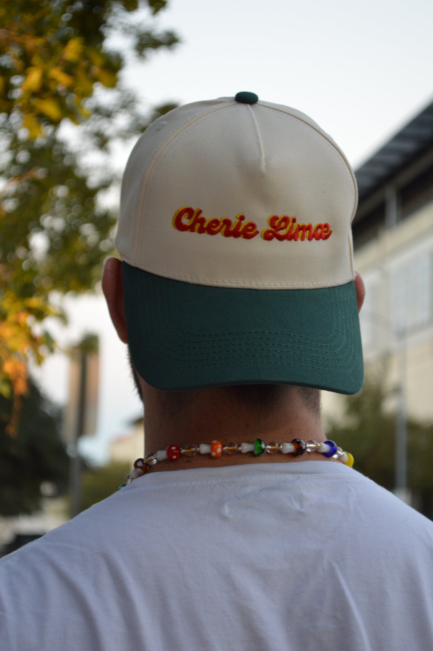 Person holding a cap with 'Charlie Pierce' branding outdoors