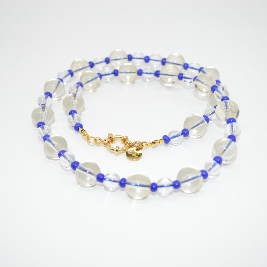 Beaded necklace with blue and gold accents on a white background