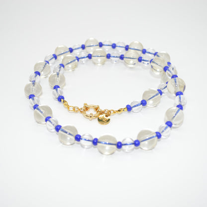 Beaded necklace with blue and gold accents on a white background