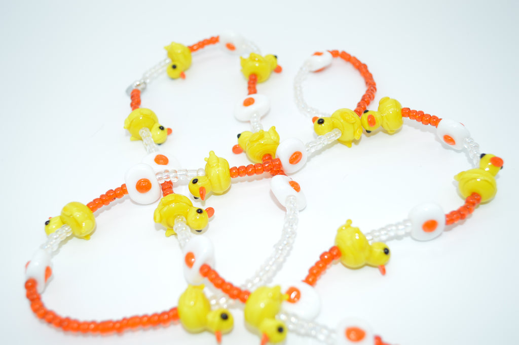 Necklace with yellow duck-shaped beads on a white background