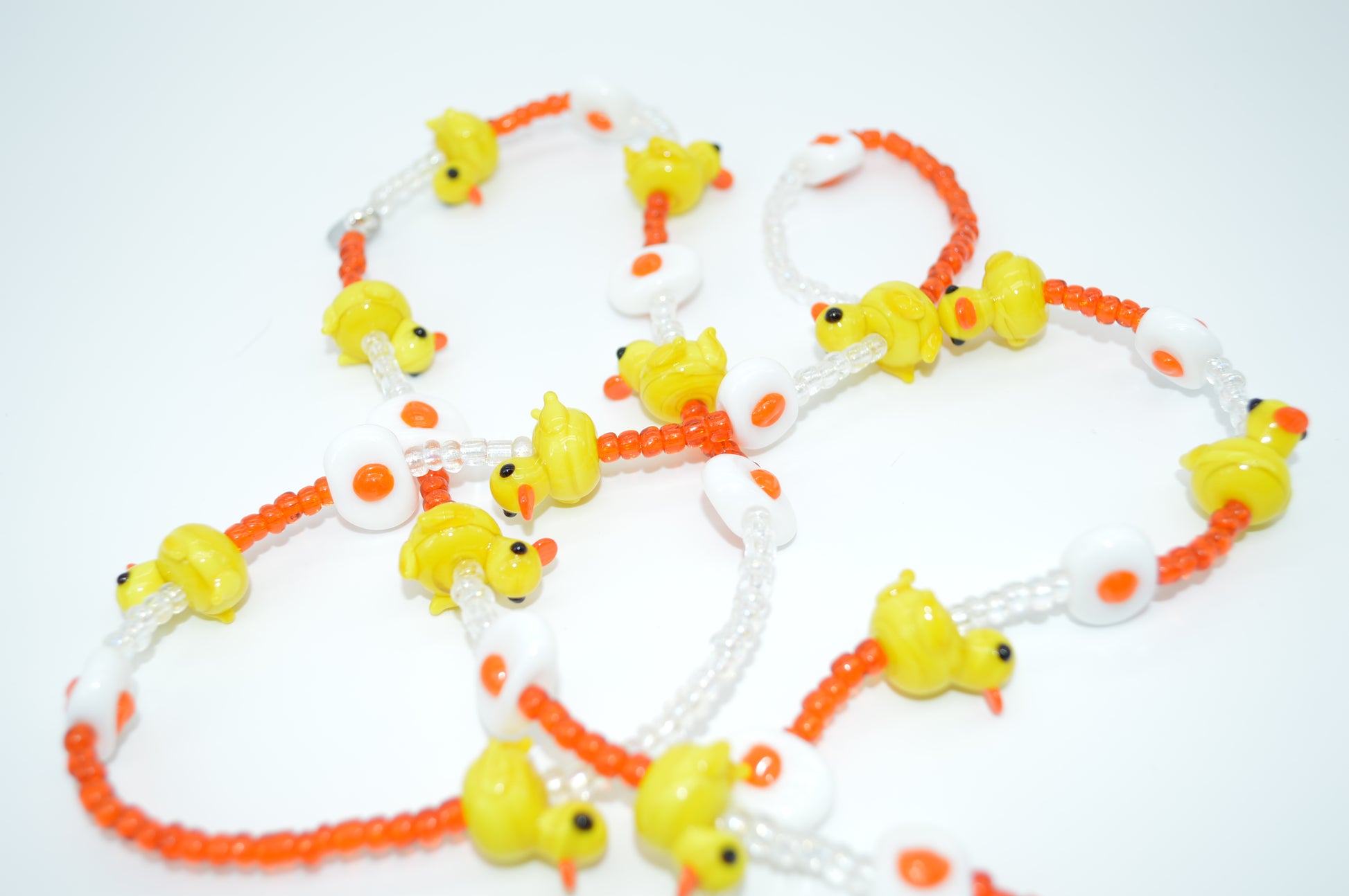 Necklace with yellow duck-shaped beads on a white background
