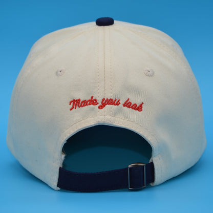 Beige cap with red text on a blue background
