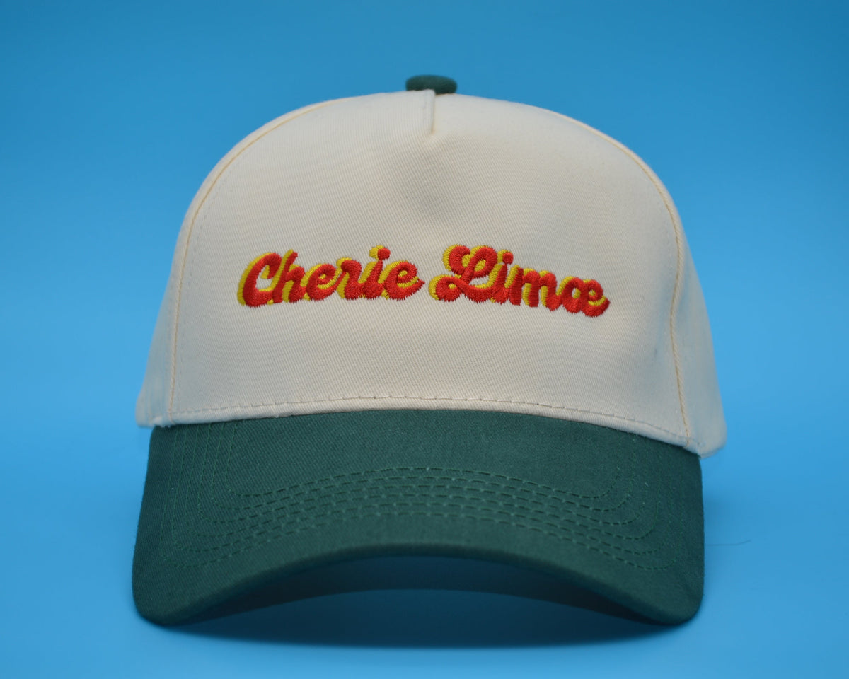 Beige and green cap with 'Cherie Lima' text on a blue background