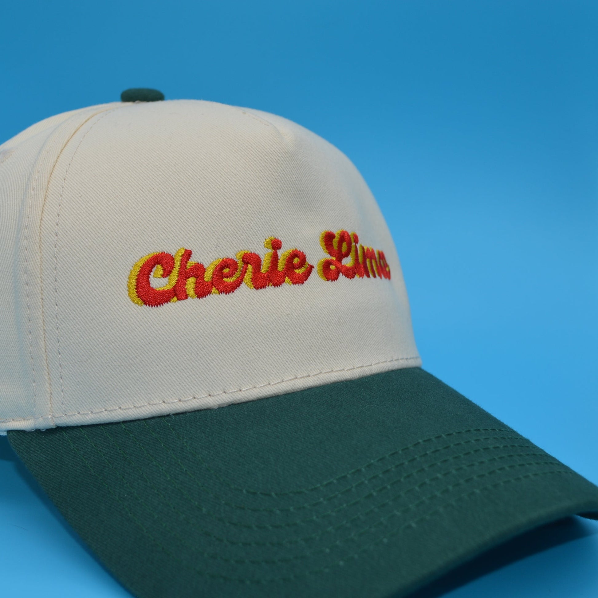 Cap with 'Cherie Line' embroidery on a blue background
