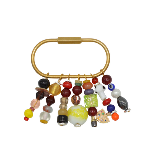 Gold ring with colorful beaded tassels on a white background