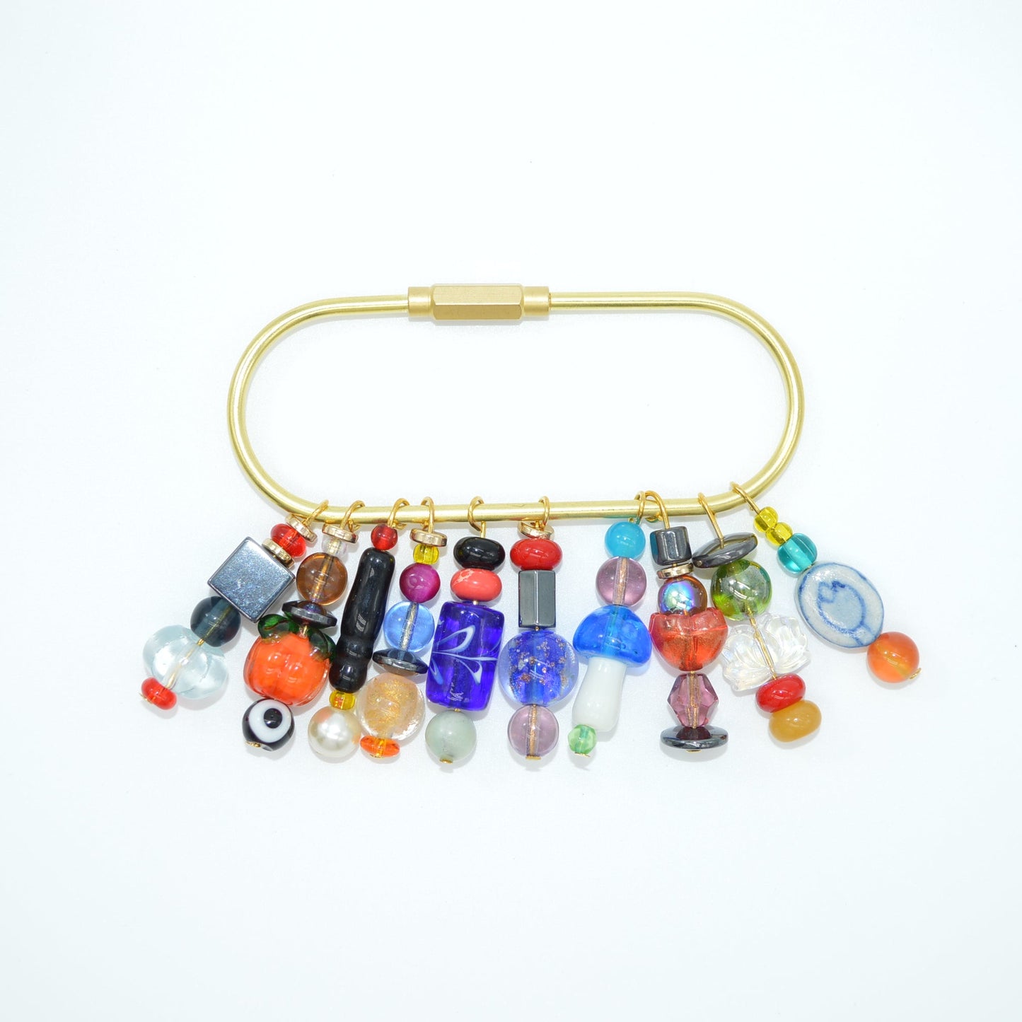 Colorful beaded pin with a gold clasp on a white background