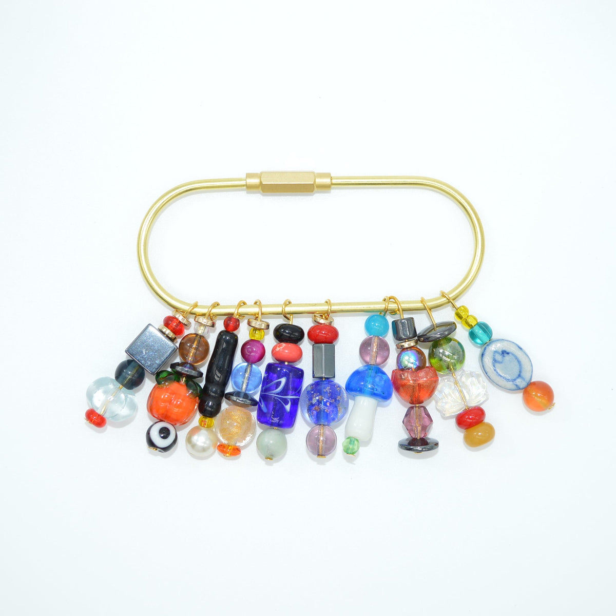 Colorful beaded pin with a gold clasp on a white background