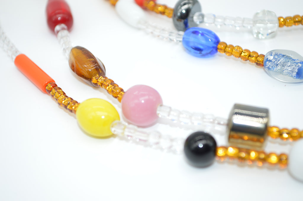 Close-up of a beaded necklace with various colored beads on a white background