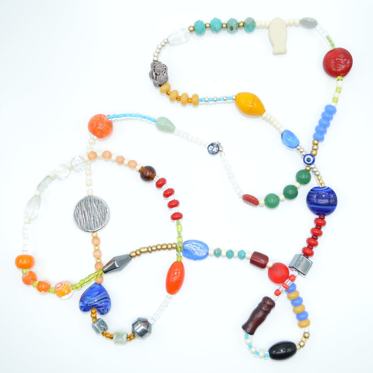 Colorful beaded bracelets arranged in a peace symbol on a white background