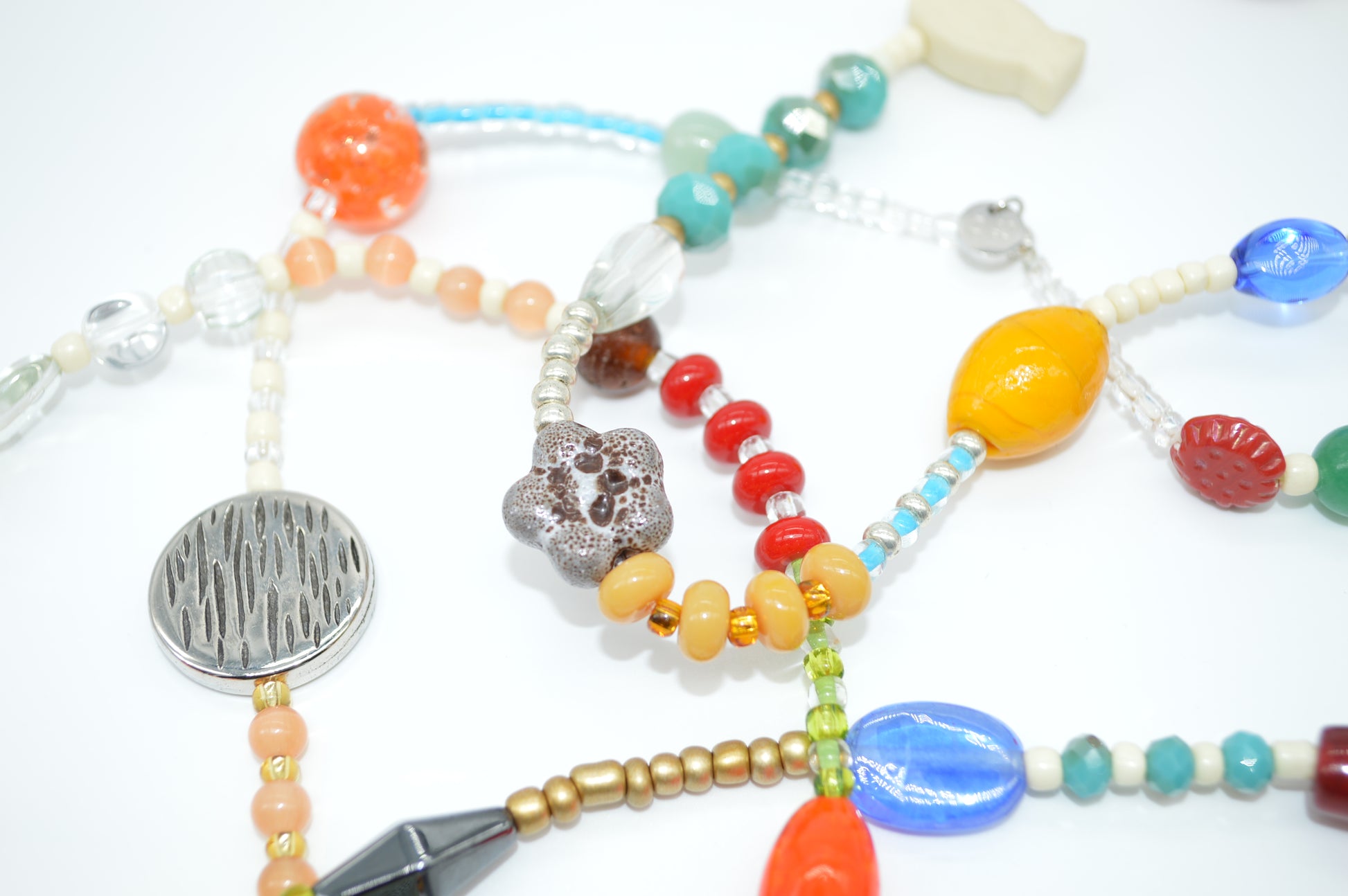 Colorful beaded necklace with various beads and a silver clasp on a white background