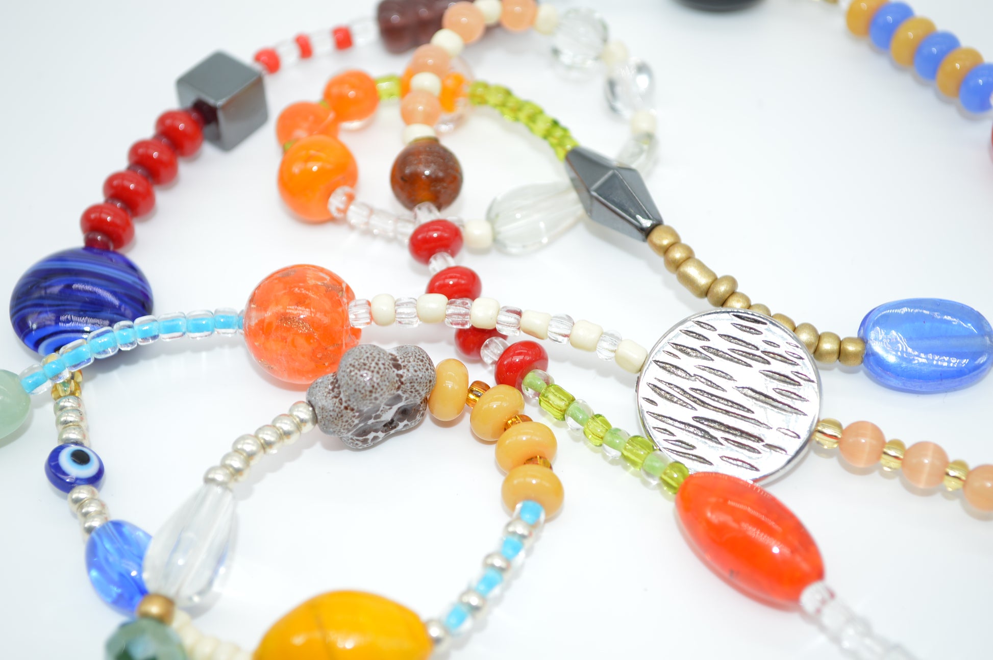 Colorful beaded necklaces on a white surface