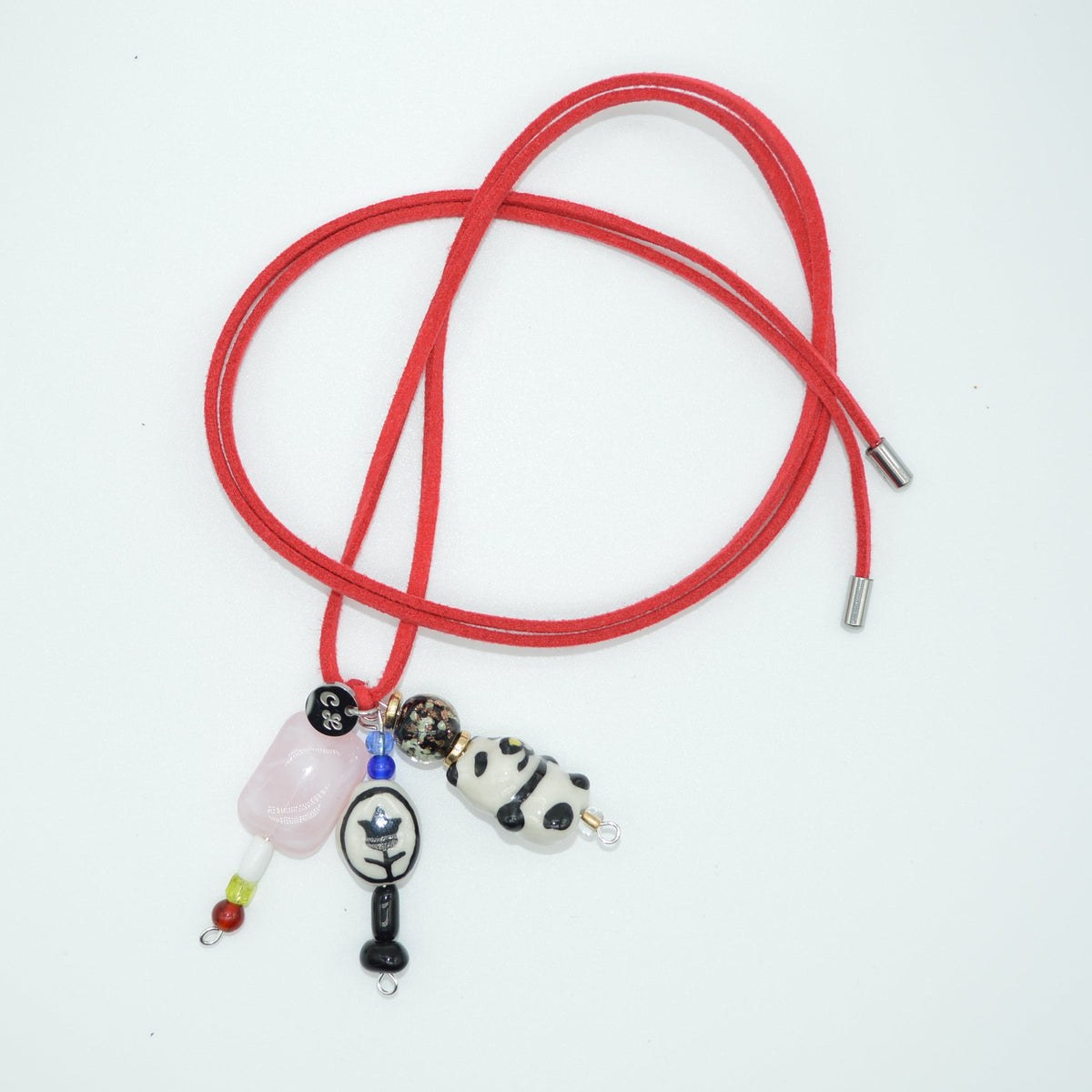Red lanyard with various charms on a white background