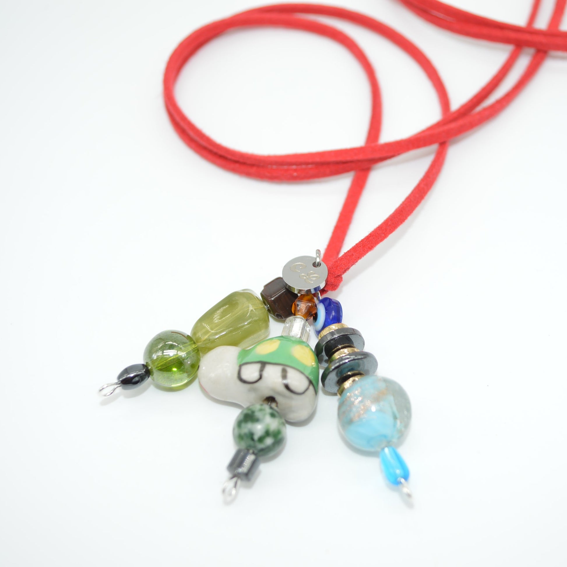 Necklace with colorful beads on a red cord against a white background