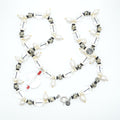 Necklace with various beads and charms on a white background
