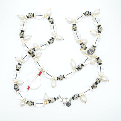 Necklace with various beads and charms on a white background