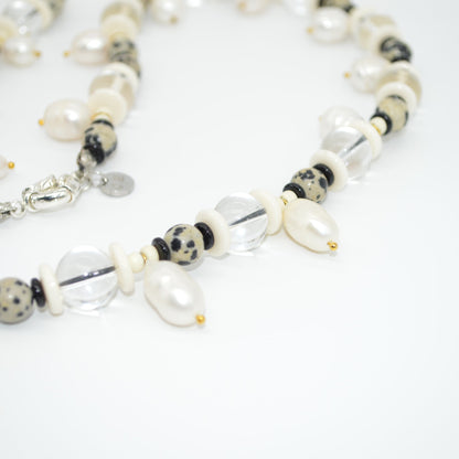 Beaded necklace with white and black beads on a light background