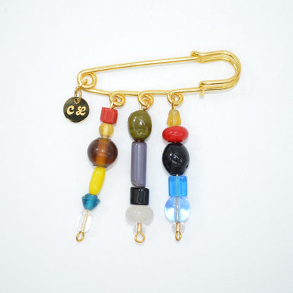 Gold brooch with colorful beads on a white background