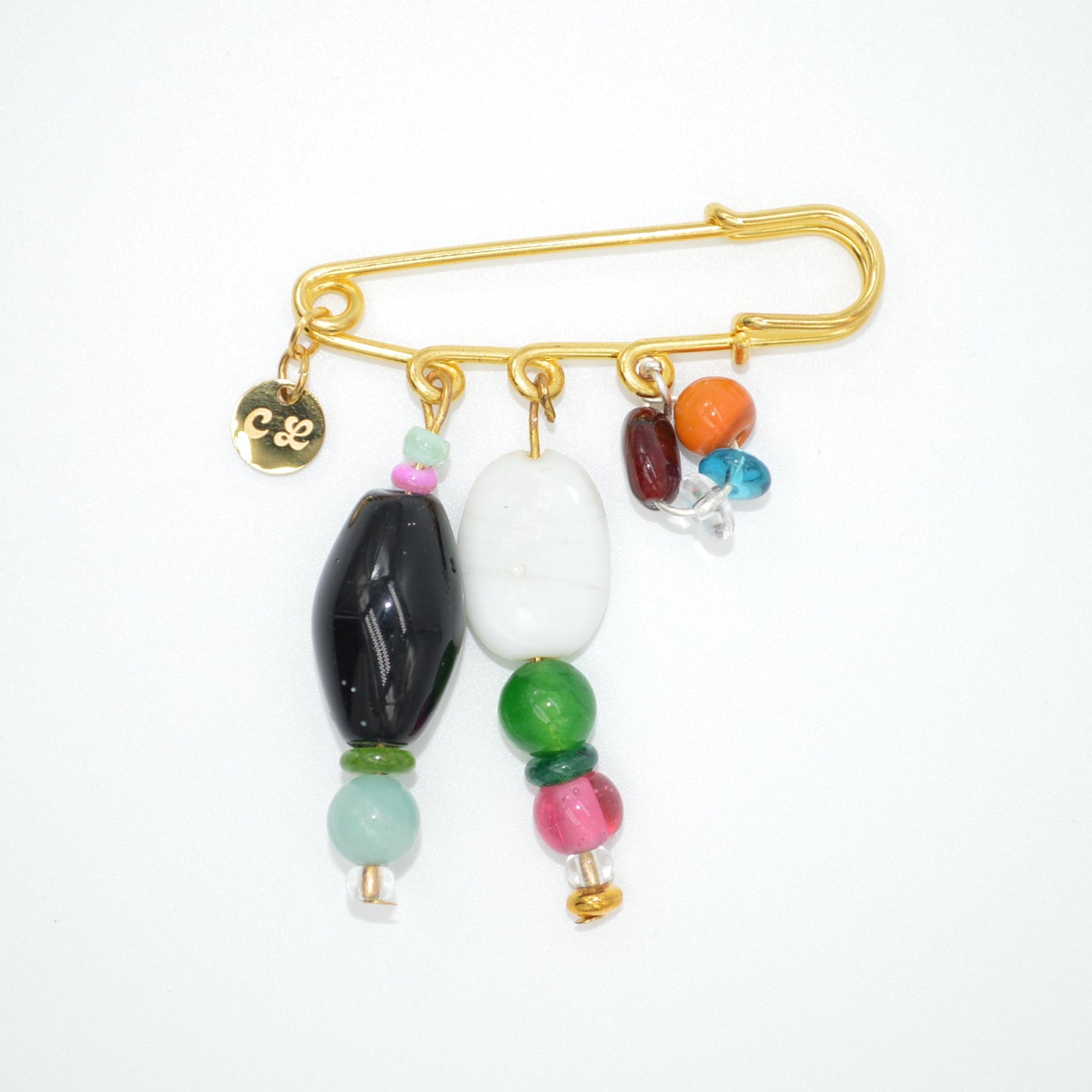 Gold brooch with colorful beads on a white background