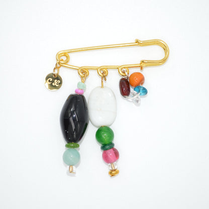 Gold brooch with colorful beads on a white background