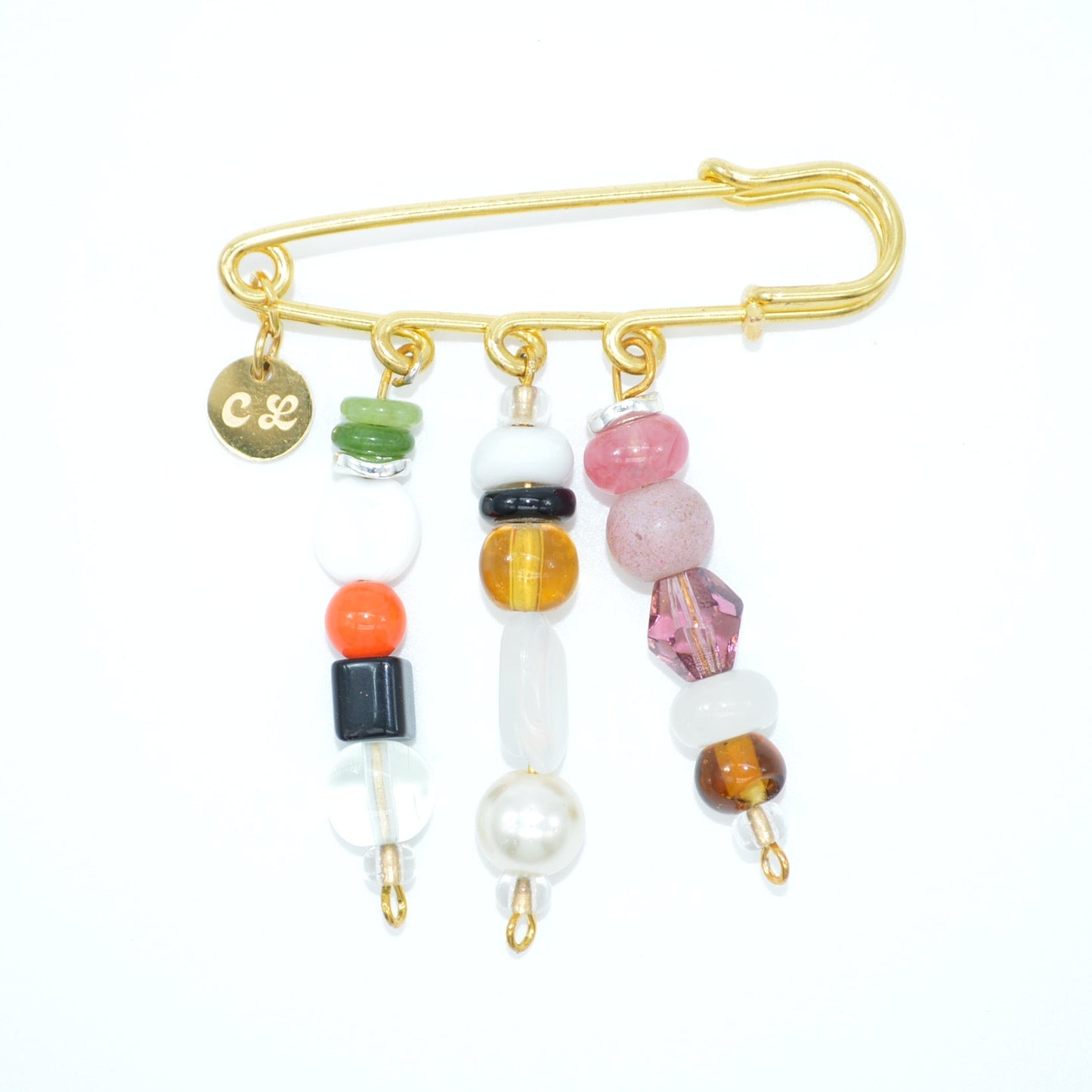 Gold safety pin with colorful beads on a white background
