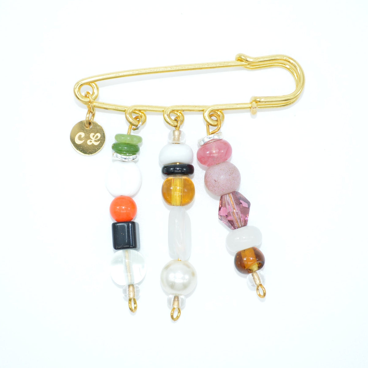 Gold safety pin with colorful beads on a white background