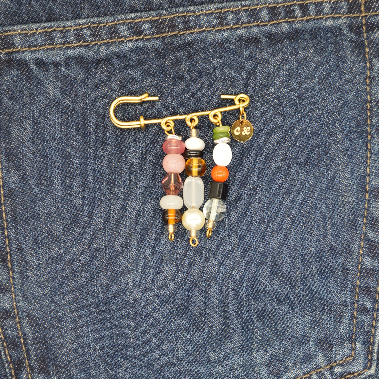 Colorful beaded keychain attached to a blue denim pocket.