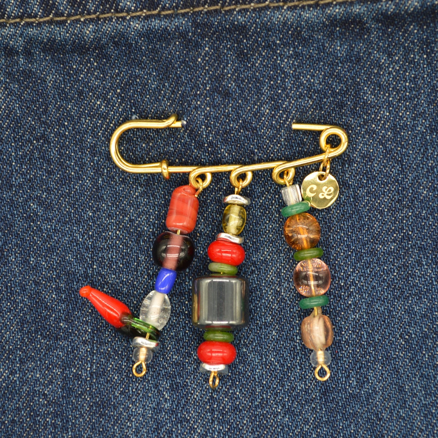 Fishing hook with colorful beads on a denim background