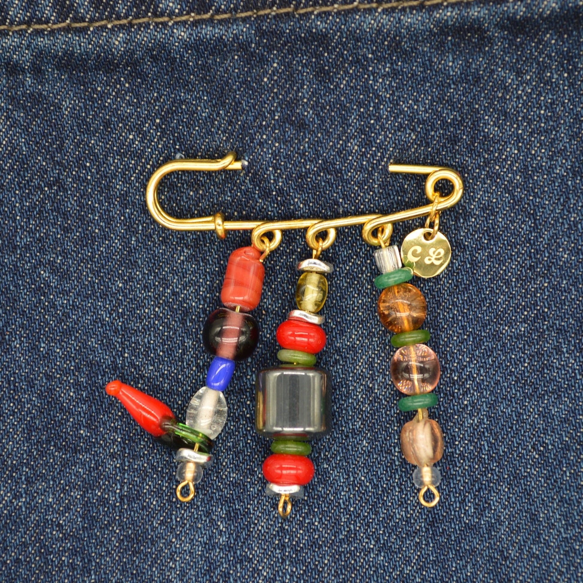 Fishing hook with colorful beads on a denim background