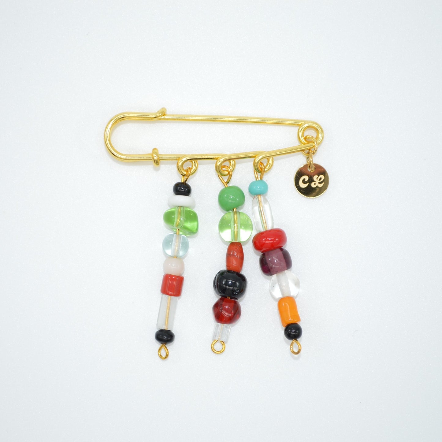 Colorful beaded brooch with gold clasp on a white background