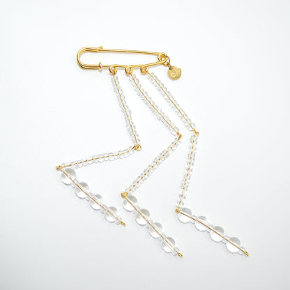 Gold necklace with clear beads on a light gray background