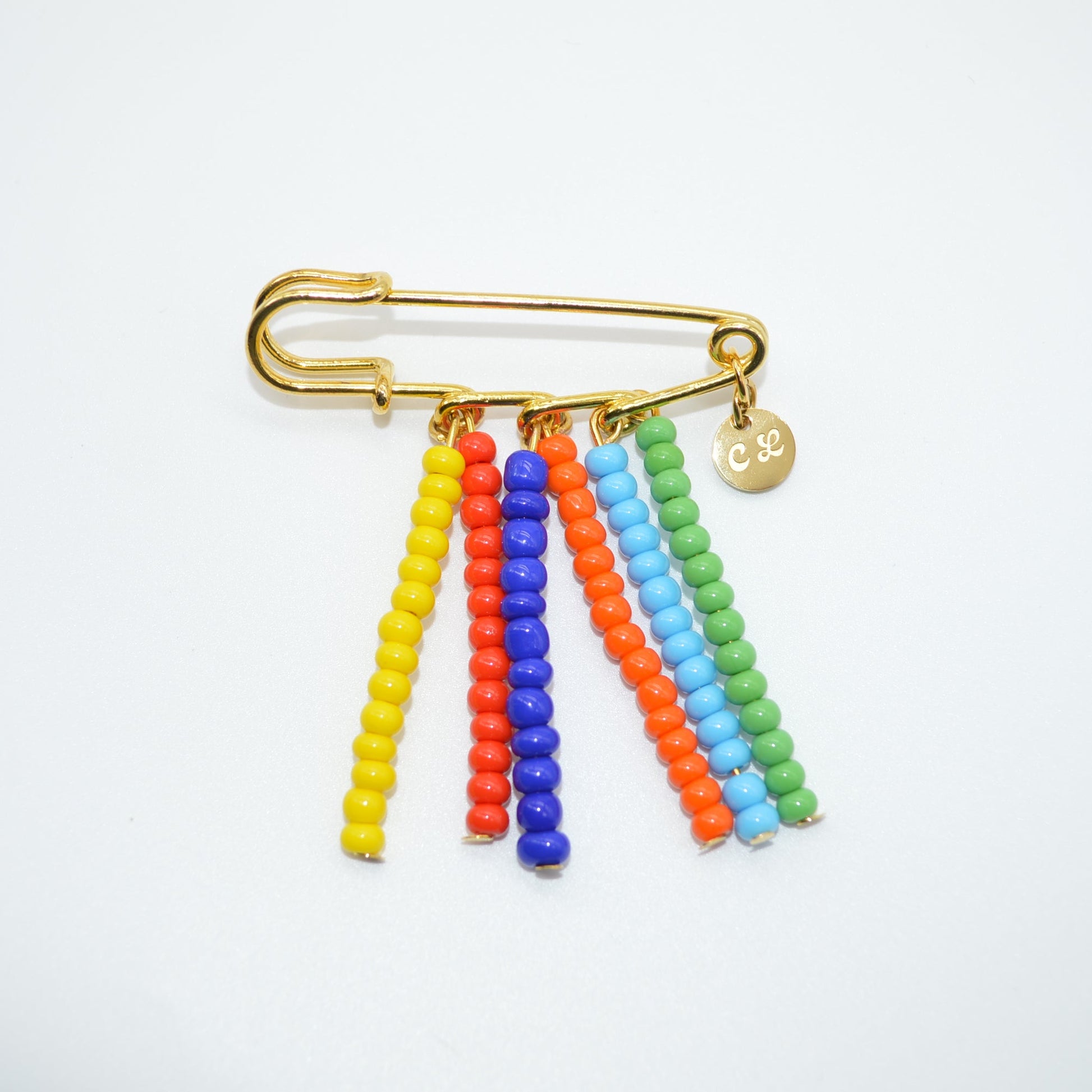 Colorful beaded brooch with a gold clasp on a white background