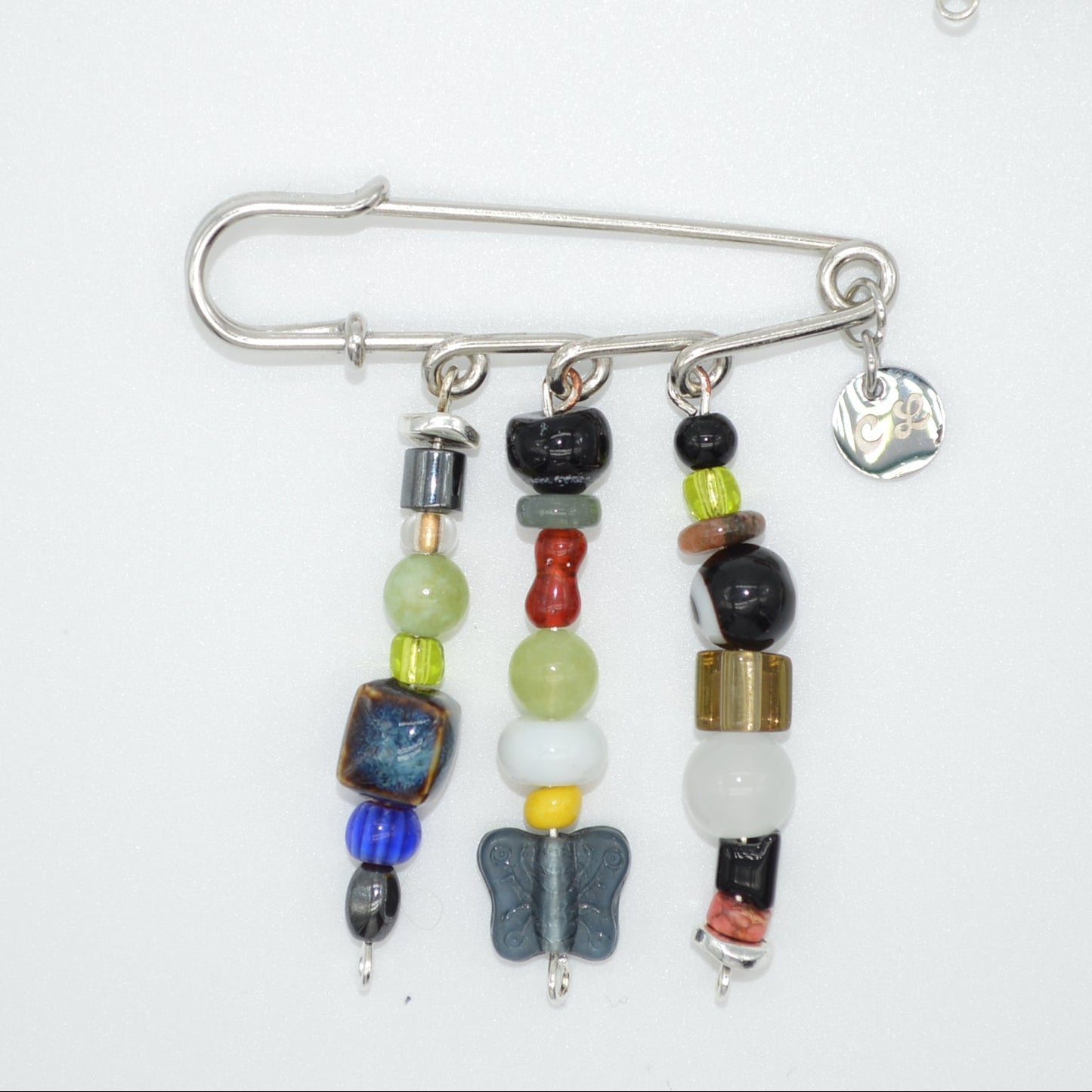 Colorful beaded brooches with metal clasps on a white background