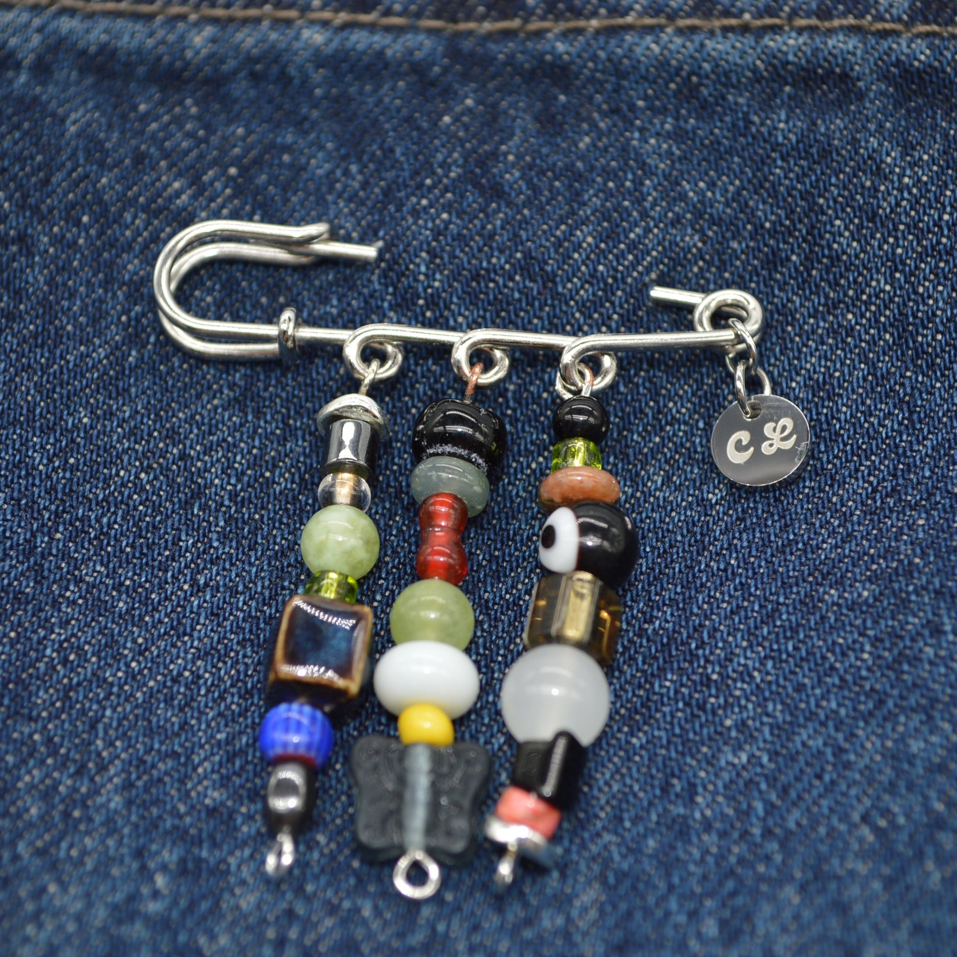 Beaded earring with colorful beads and metal components on a denim background