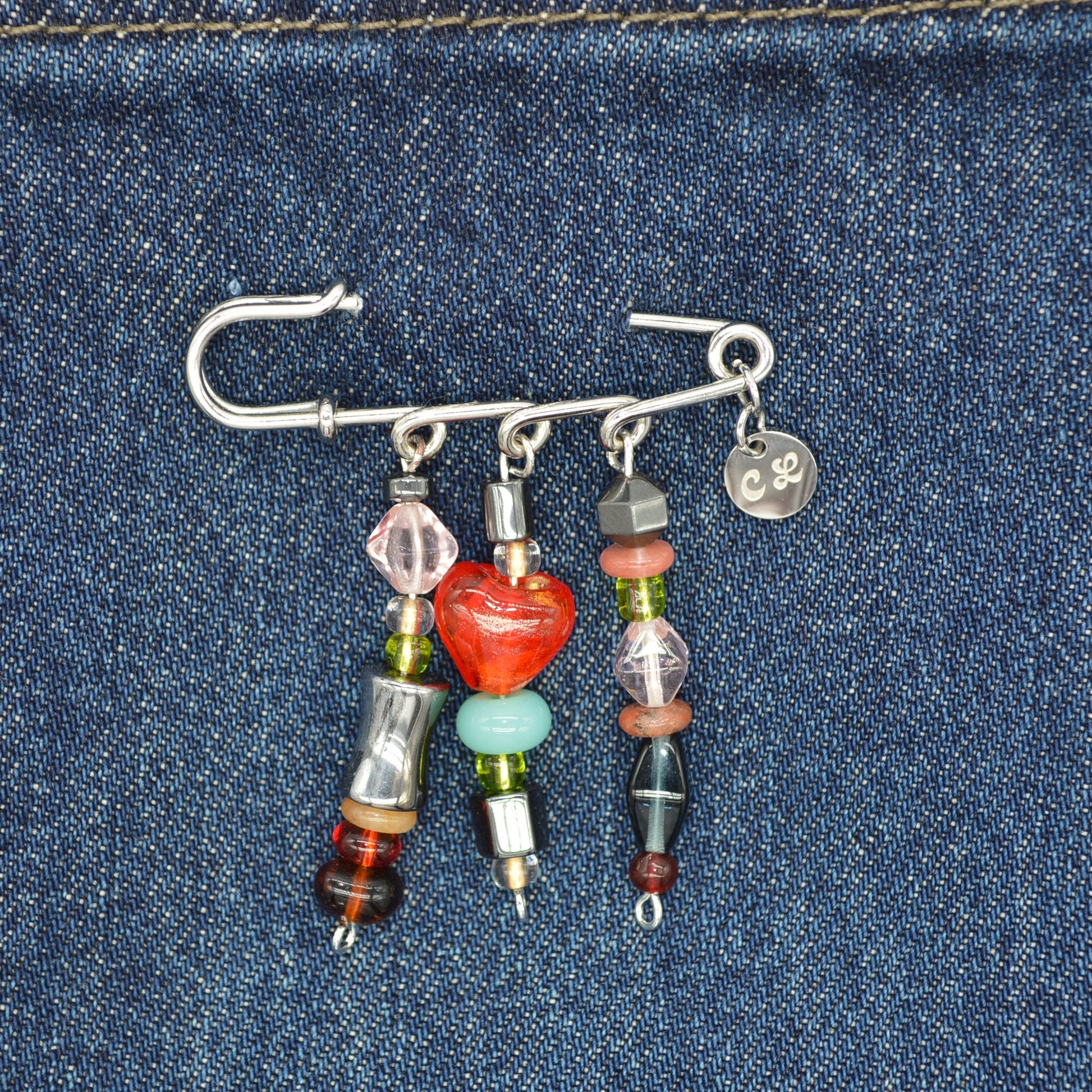 Beaded brooch with colorful beads on a denim background