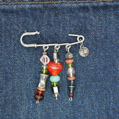 Beaded brooch with colorful beads on a denim background