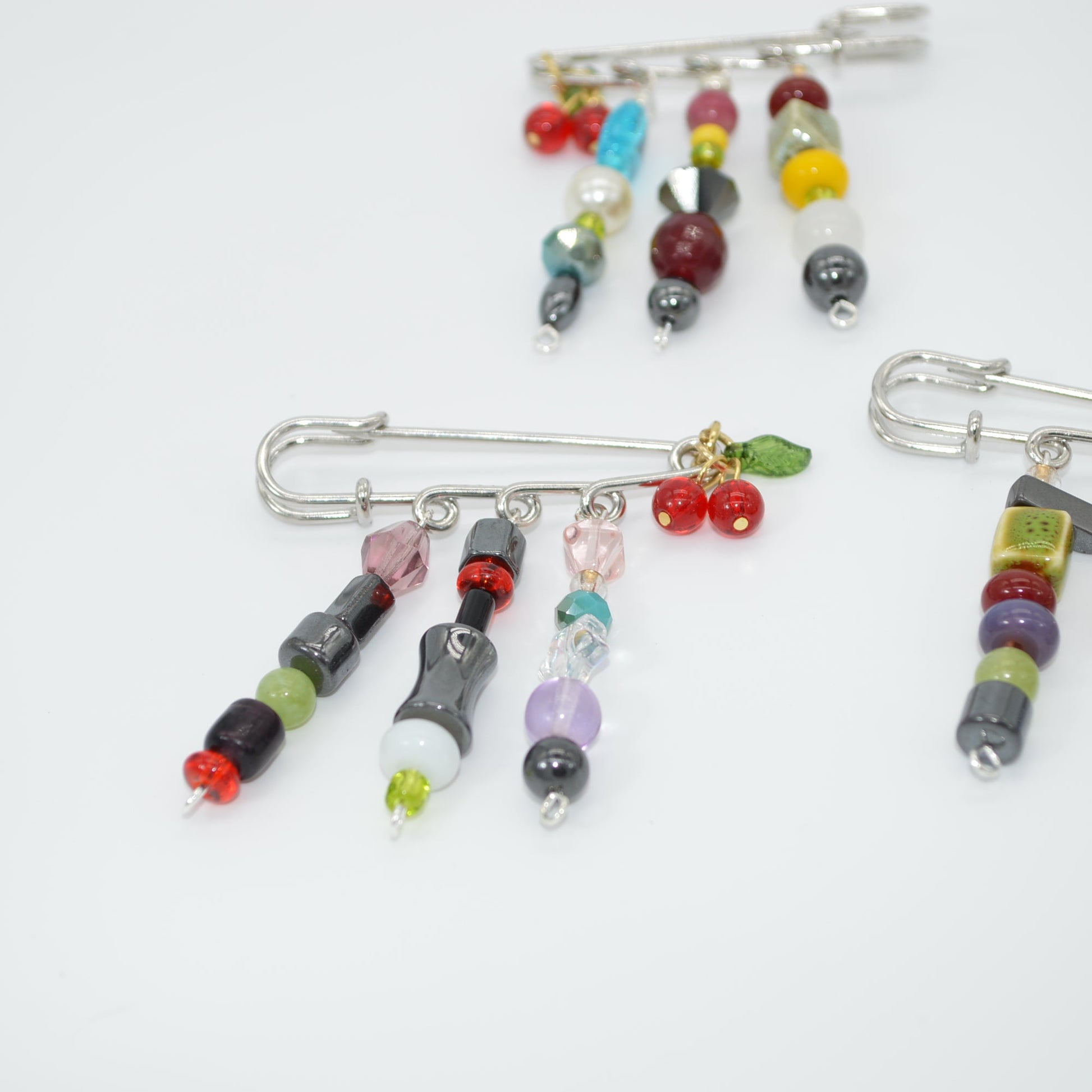 Colorful beaded brooches on a white background