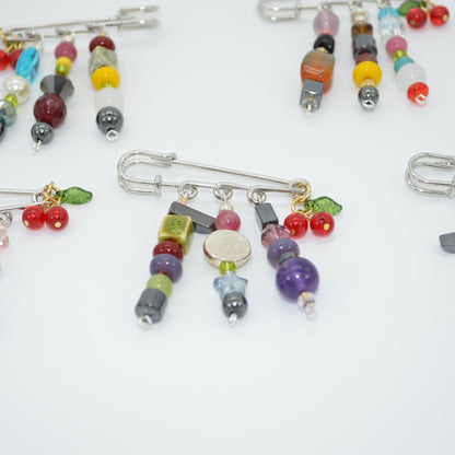 Colorful beaded brooches on a white background