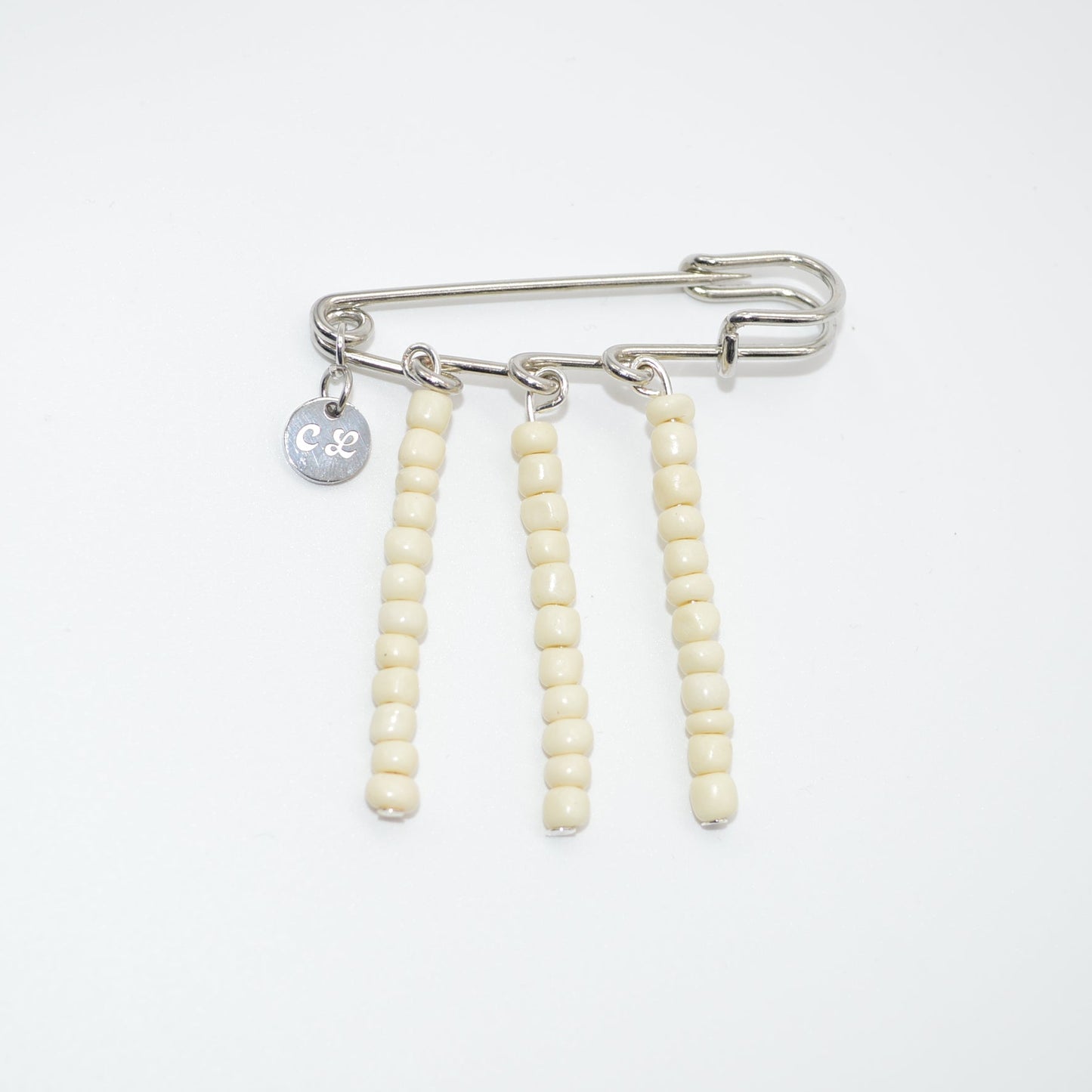 Brooch with safety pin and beaded extensions on a white background