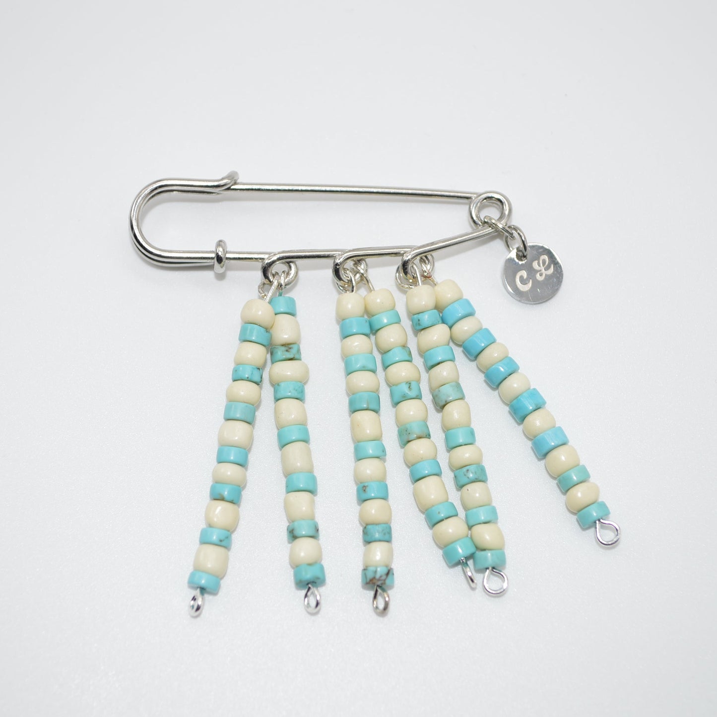 Beaded keychain with turquoise and white beads on a white background