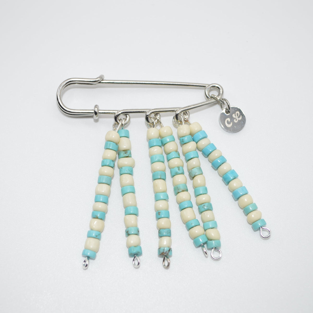 Beaded keychain with turquoise and white beads on a white background