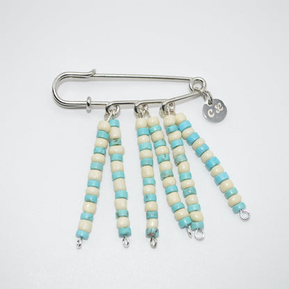 Beaded keychain with turquoise and white beads on a white background
