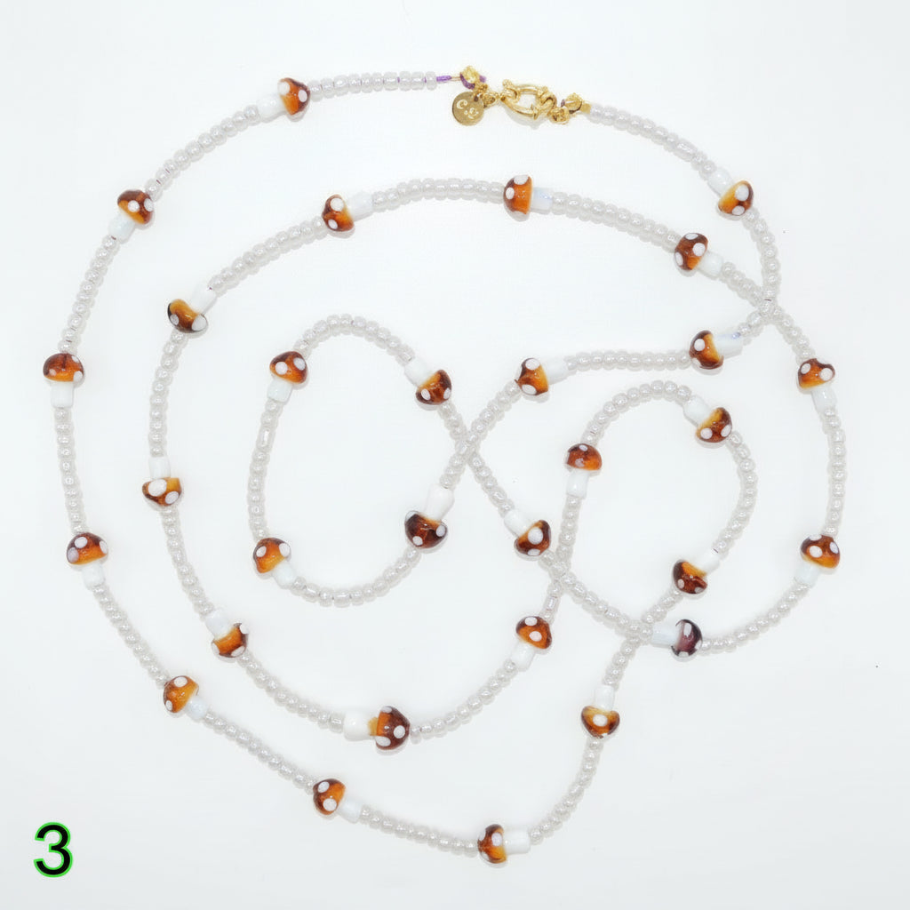 Beaded necklace with white and brown beads on a white background