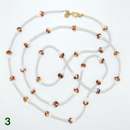 Beaded necklace with white and brown beads on a white background