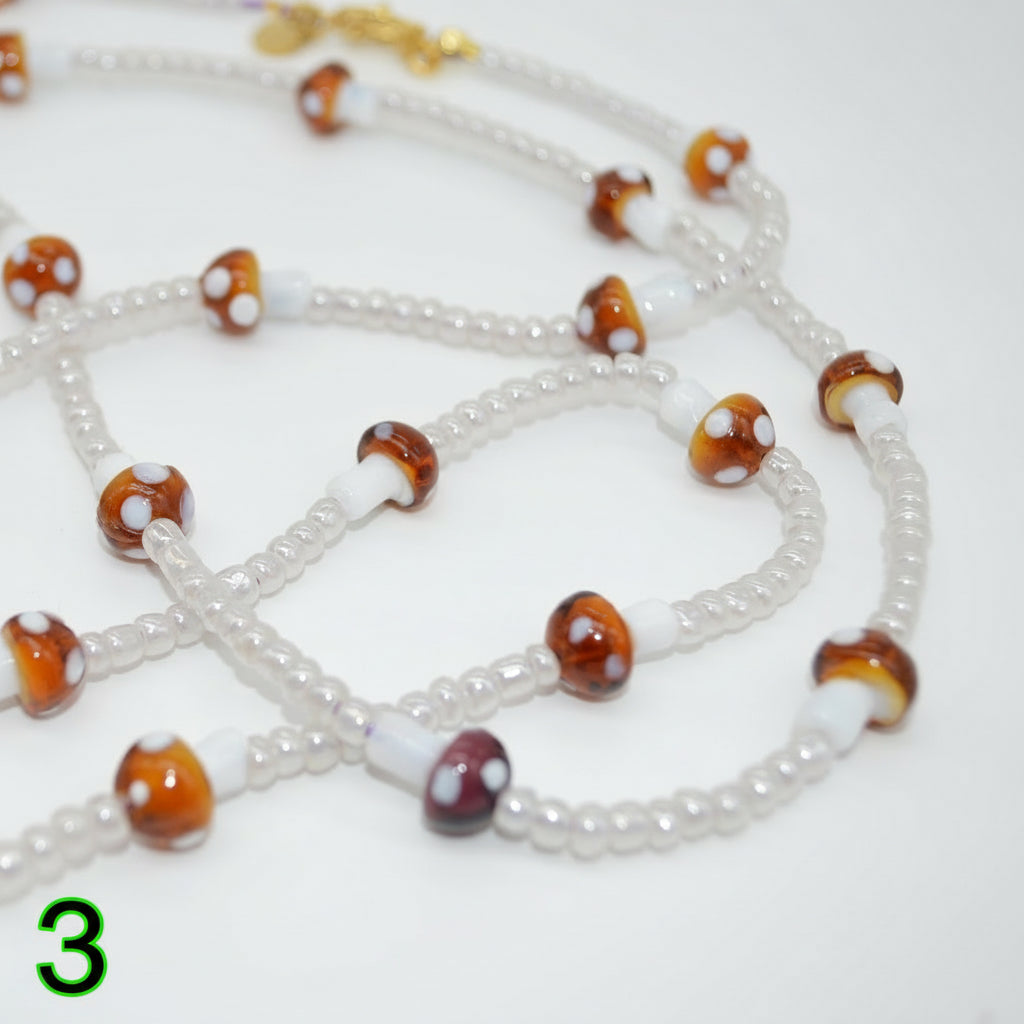 Beaded necklace with brown and white beads on a white background