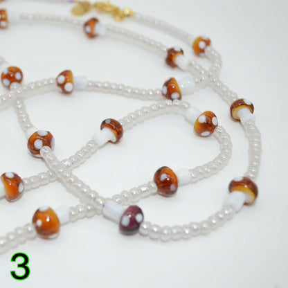 Beaded necklace with brown and white beads on a white background