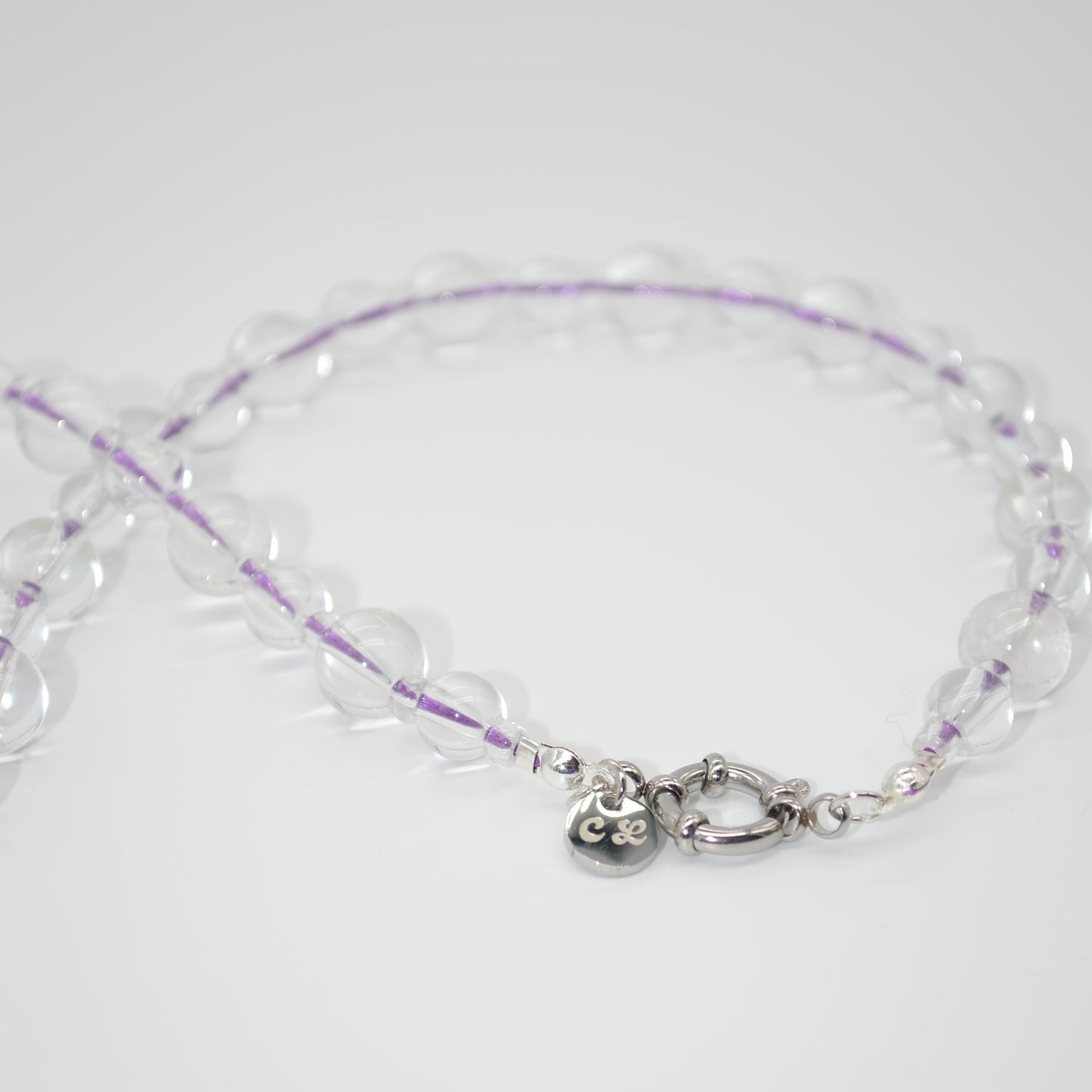 Clear beaded necklace with a silver clasp on a white background
