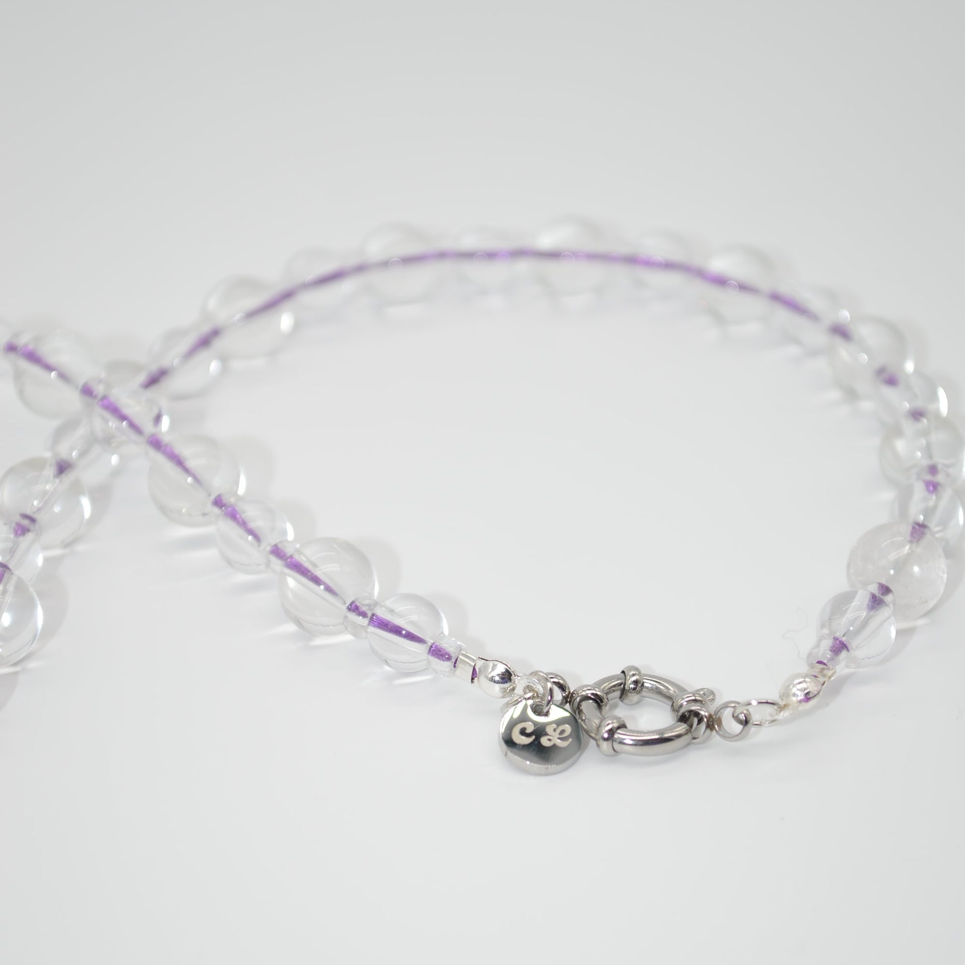 Clear beaded necklace with a silver clasp on a white background
