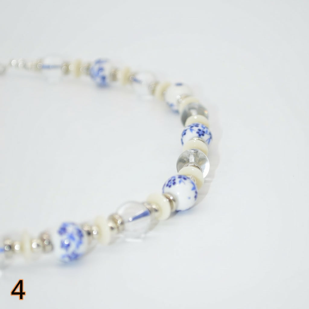 Necklace with blue and white beads on a light gray background